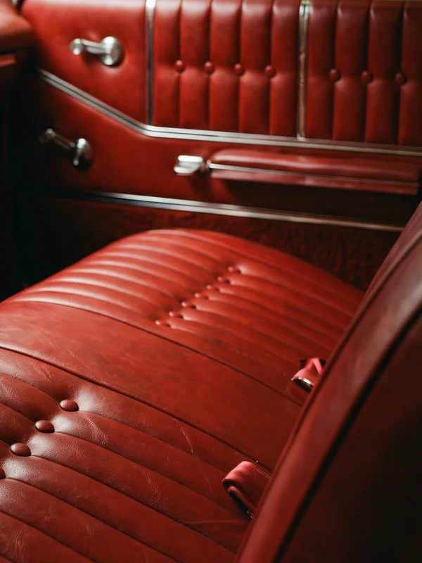 Close-up of Gil's work in the '64: button-tufted door panel above a pleated red bench